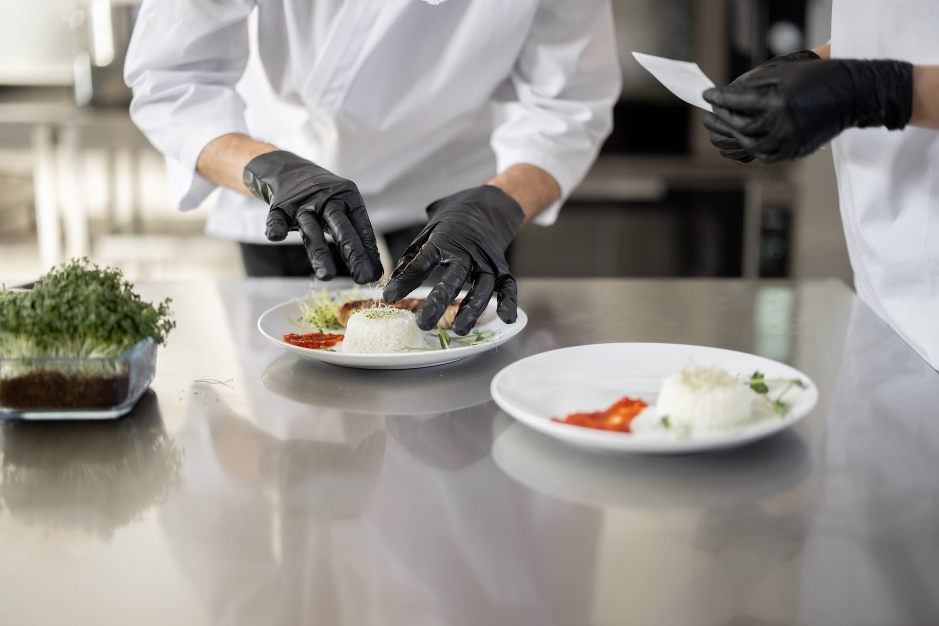 Caterman cooks finishing main courses in the kitchen