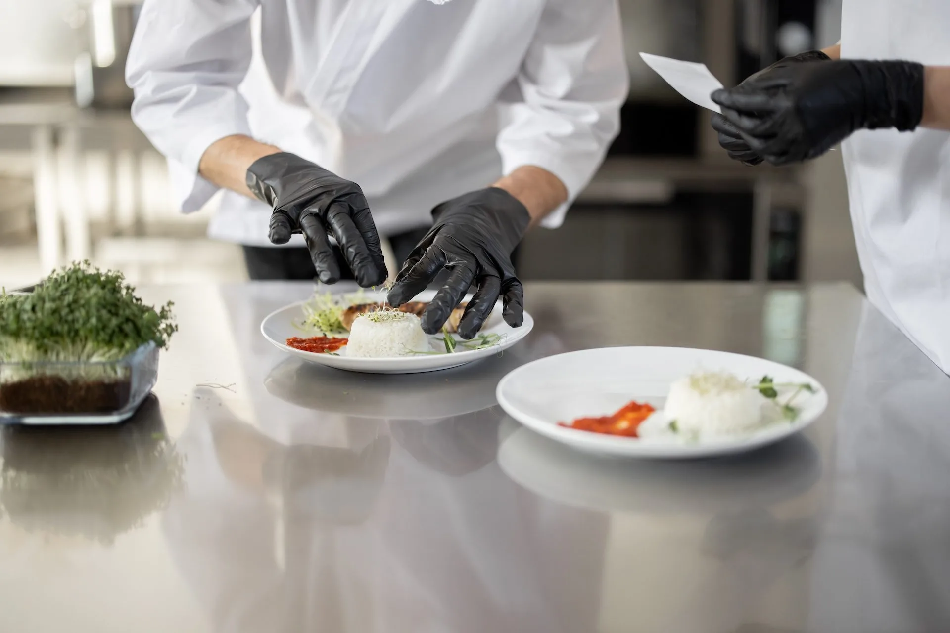 Caterman cooks finishing main courses in the kitchen