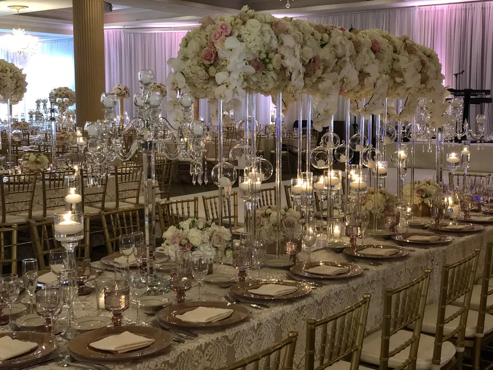 Long banquet table with tall floral centrepieces and candlelight