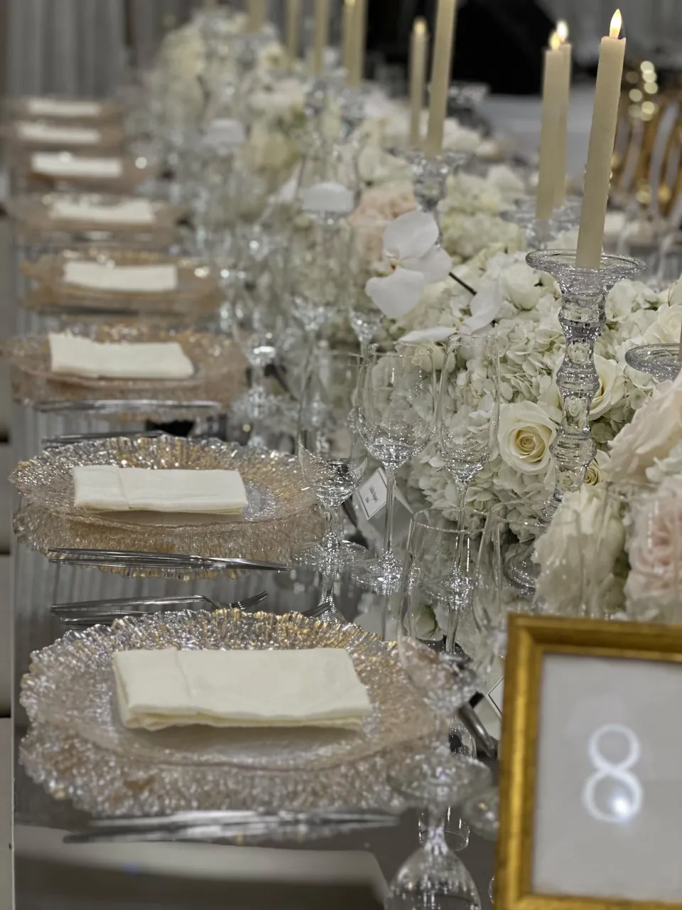 Place setting with crystal, ivory linen and tall candles