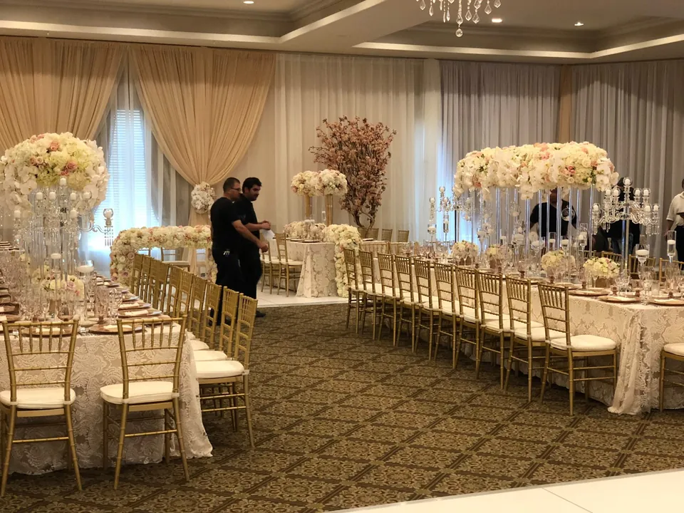 Ballroom reception with tall white florals and gold chiavari chairs