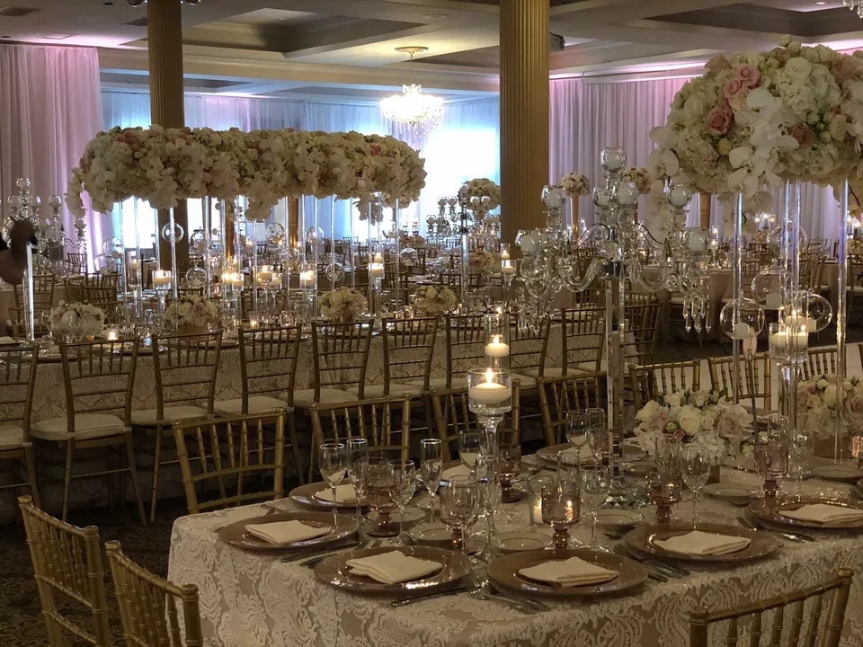 Ballroom tables with raised floral arrangements and crystal glassware