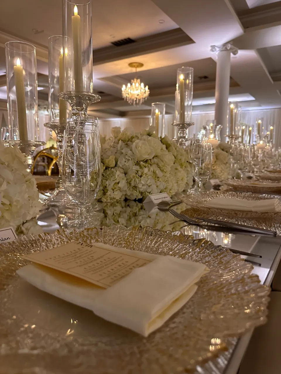 Close up of a table setting with white florals and candlelight