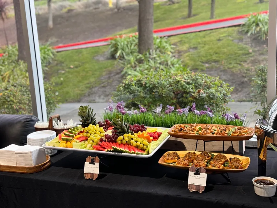 Fruit and pastry buffet by a window overlooking a garden