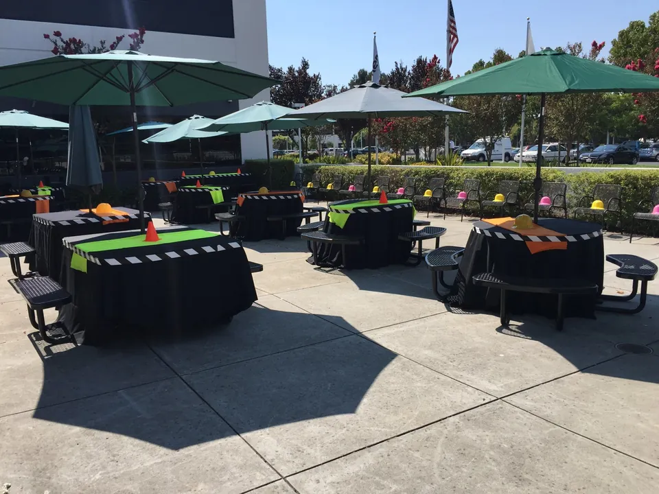 Outdoor corporate lunch with black linen and green umbrellas