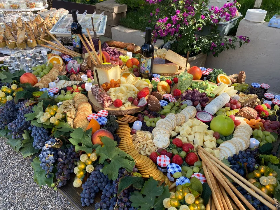 Grazing table with cheese, grapes, berries and breadsticks