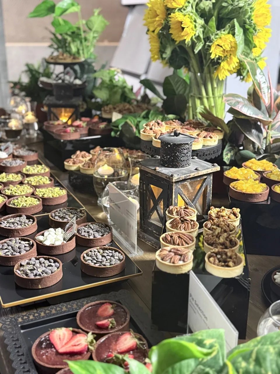 Tiered stands of canapés and small bites with sunflowers