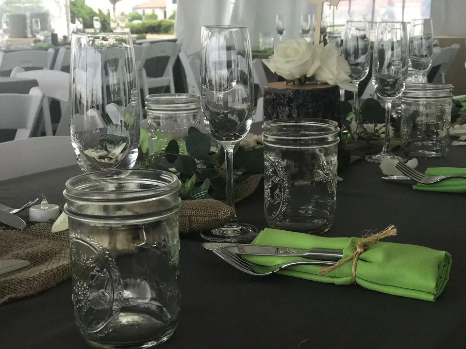 Mason jar glassware with a green napkin and burlap place mat